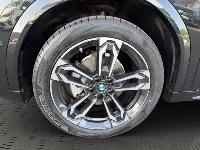 Gros plan sur la roue avant gauche noire d’un BMW X2 2025 avec jante alliage au design moderne.