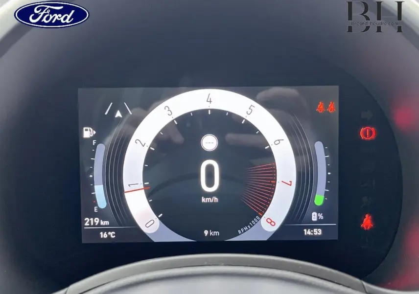 Tableau de bord numérique de Ford, affichant la vitesse à 0 km/h et divers indicateurs, cadran central circulaire.