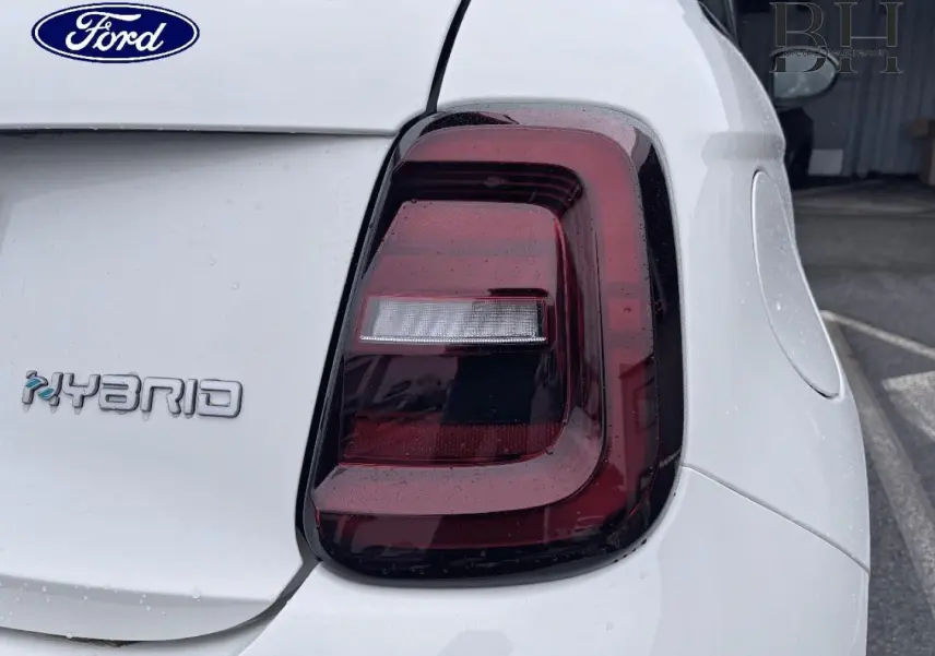 Gros plan sur le feu arrière droit d'une FIAT 500 Ice White pastel avec logo Hybrid sur fond blanc.