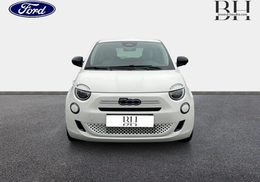 Vue frontale d'une FIAT 500 Ice White pastel 2026 avec logo noir et phares ronds LED, sur fond neutre.