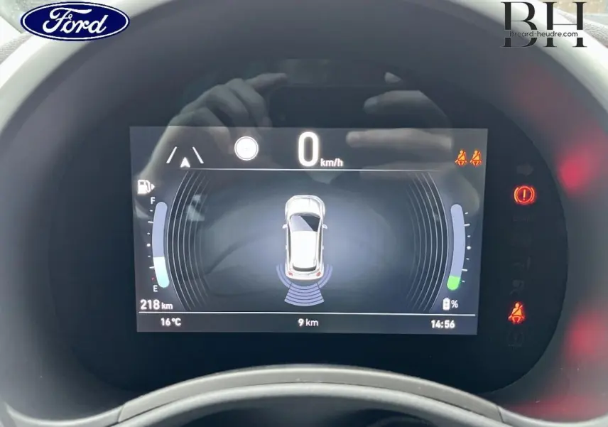Tableau de bord numérique de la Fiat 500 Ice White pastel, affichant la vitesse à 0 km/h et les capteurs de proximité actifs.