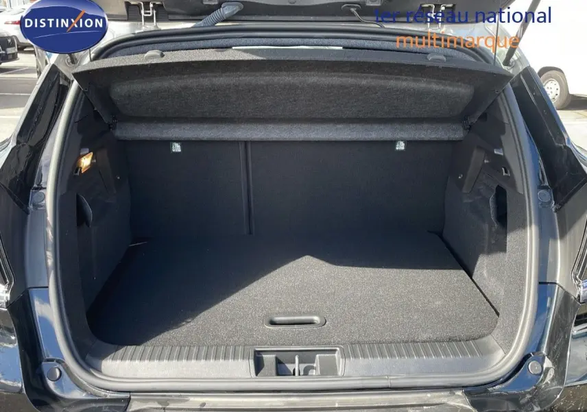 Coffre ouvert vu de l'arrière d'un Renault Captur noir étoile métal, montrant l'espace de chargement vide et propre.