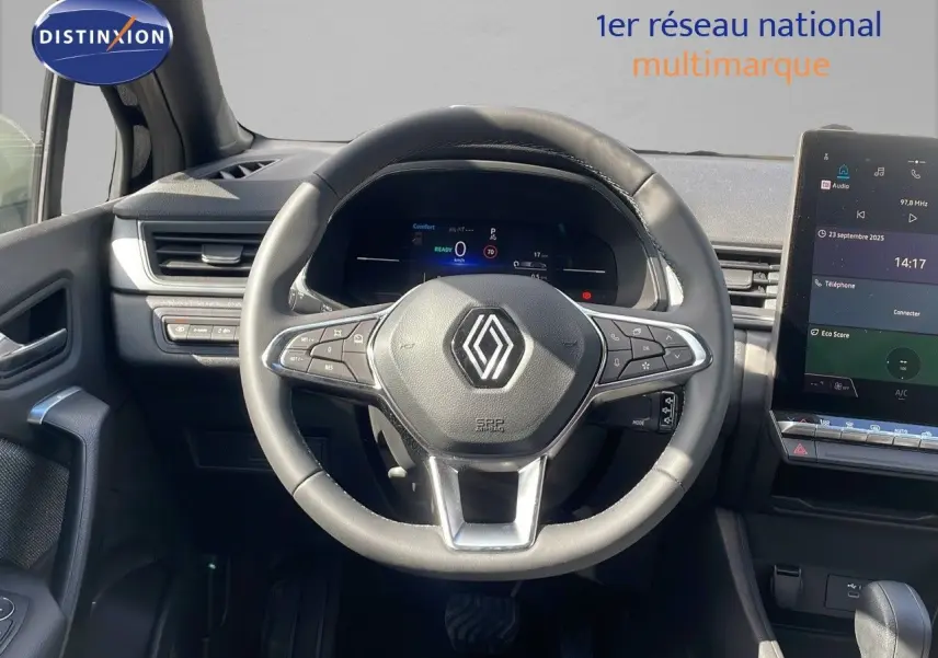 Vue intérieure centrée sur le volant Renault du Captur 2025, avec tableau de bord numérique et écran tactile visible.