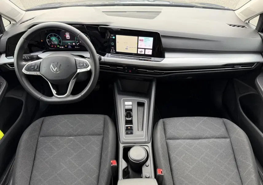 Vue intérieure avant de la Volkswagen Golf 2023 montrant le tableau de bord digital et la console centrale moderne.