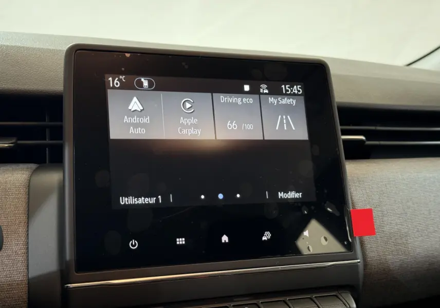 Écran tactile central affichant Android Auto et Apple CarPlay dans l'habitacle d'une Renault Clio gris clair.