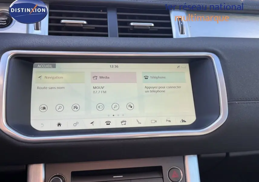 Écran tactile central du Range Rover Evoque blanc de 2017, affichant navigation, média et téléphone, tableau de bord noir.