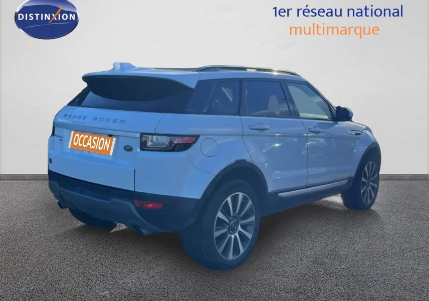 Range Rover Evoque blanc vu en 3/4 arrière côté droit, avec jantes alliage et toit noir contrasté.