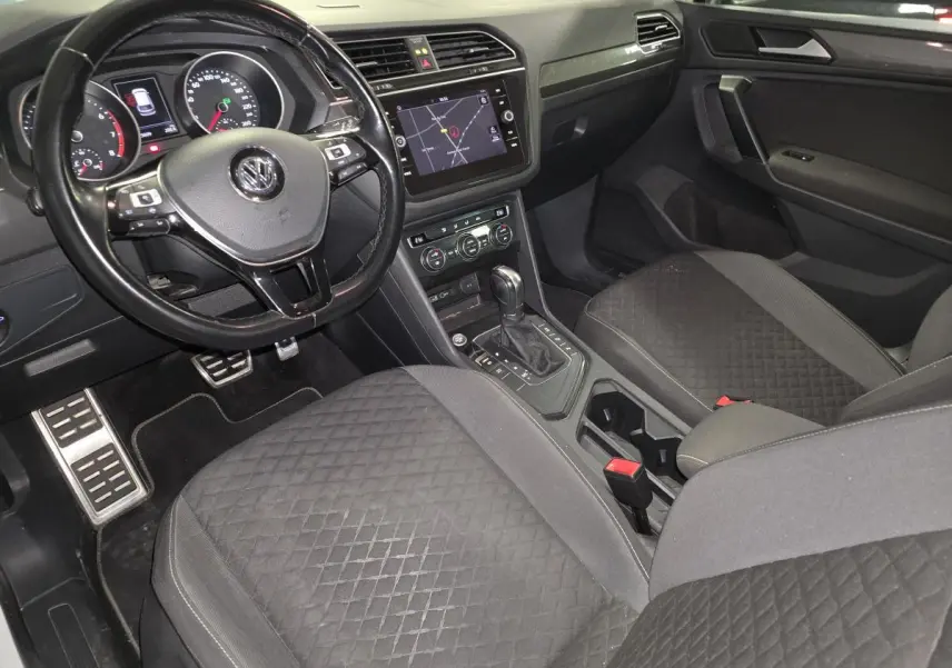 Intérieur noir du Volkswagen Tiguan 2019, vue côté conducteur avec tableau de bord et console centrale tactile.