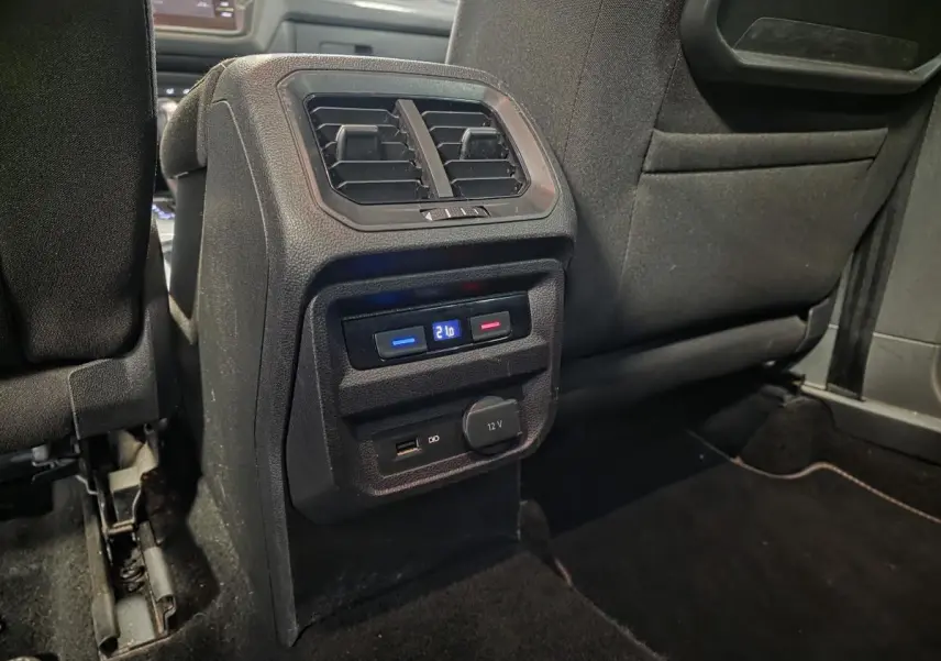 Vue rapprochée de la console arrière noire du Volkswagen Tiguan 2019 avec sorties d'air, réglage de température et prises USB et 12V.