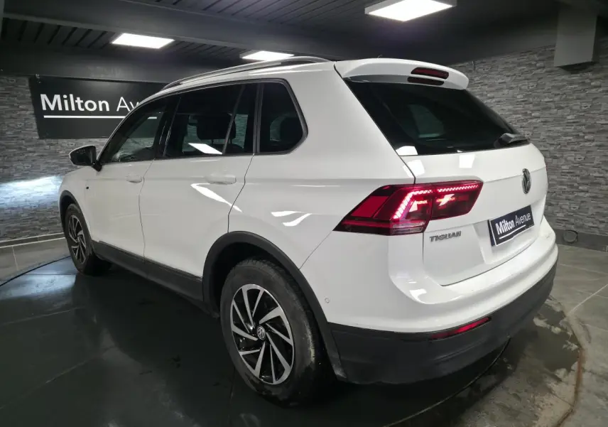Volkswagen Tiguan blanc vue 3/4 arrière droit avec feux LED et jantes alliage 17 pouces en intérieur showroom.