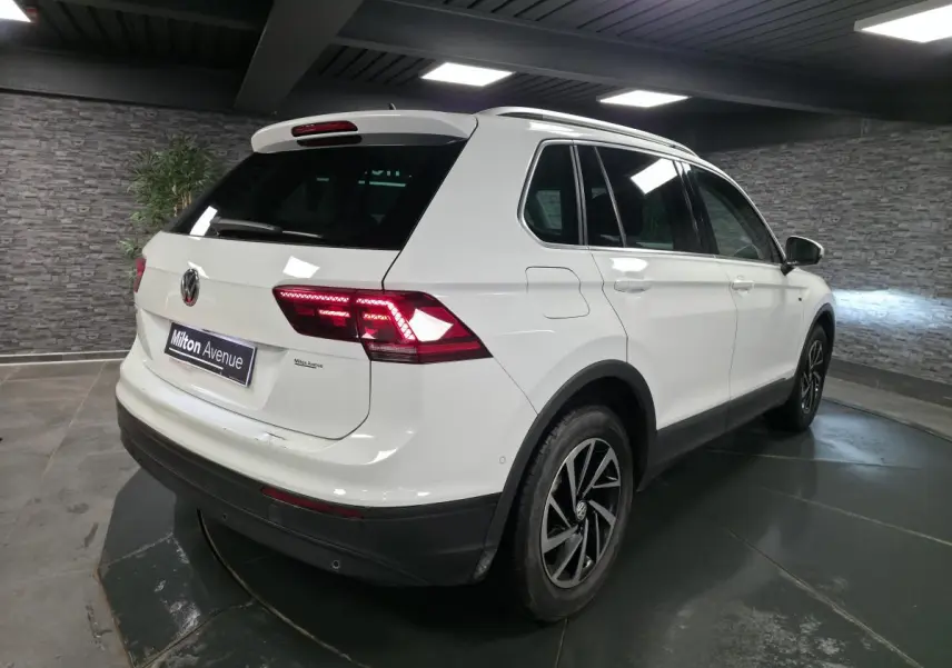 Vue 3/4 arrière droit d'un Volkswagen Tiguan blanc avec feux arrière LED et jantes alliage 17 pouces.