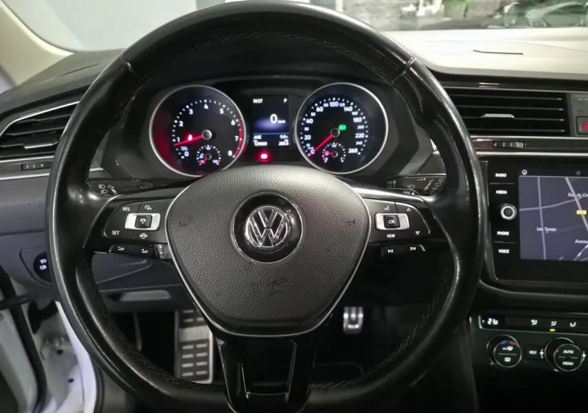 Vue rapprochée du volant en cuir noir et du tableau de bord numérique du Volkswagen Tiguan blanc 2019.