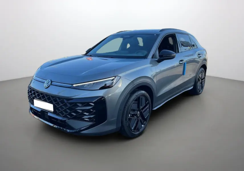 Volkswagen T-Roc gris loup en 3/4 avant droit, avec jantes noires et toit ouvrant panoramique visible.