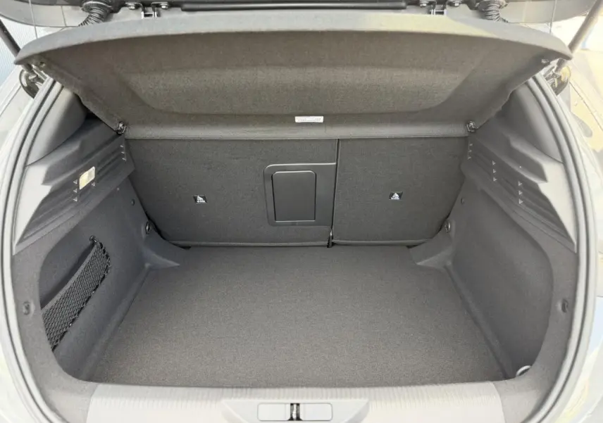 Coffre ouvert de la Peugeot 308 NV Hybrid 145 GT e-DSC6 gris Selenium, montrant un espace de chargement propre et bien fini.