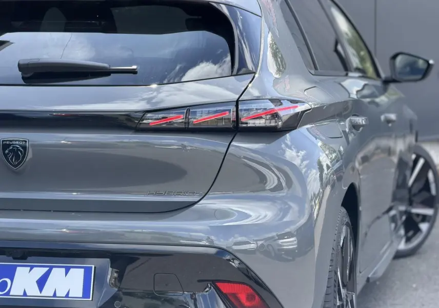 Vue 3/4 arrière droite d’une Peugeot 308 gris Selenium avec feux arrière LED en forme de griffes et jantes alliage bi-tons.