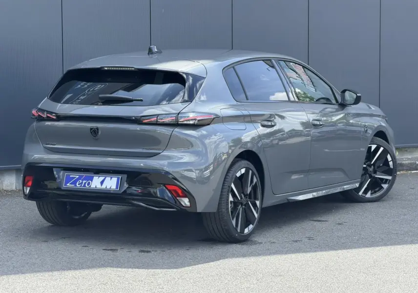 Peugeot 308 NV Hybrid gris Selenium vue 3/4 arrière droit, jantes alliage bi-tons et feux arrière LED 3 griffes.