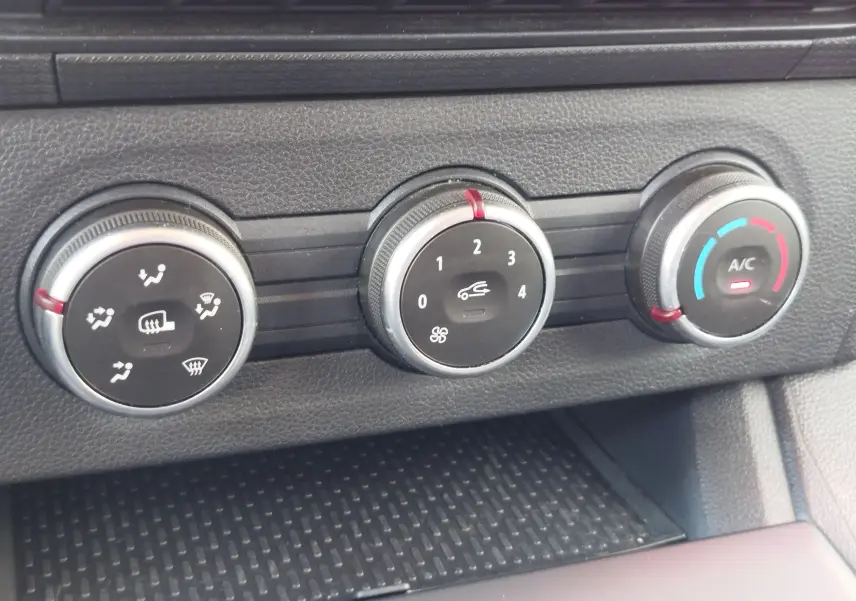 Gros plan sur les commandes de climatisation du Renault Kangoo 2023, avec réglages de ventilation, air recyclé et température.