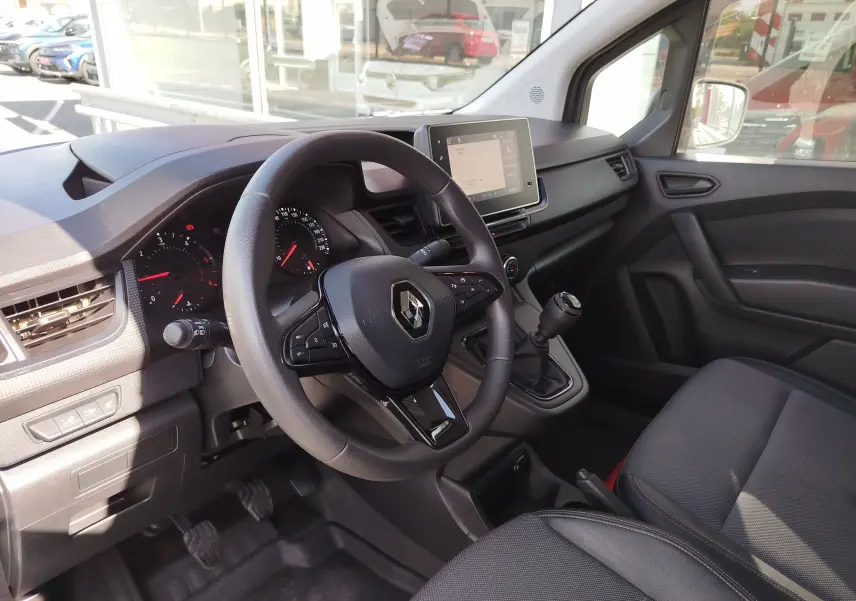Vue intérieure côté conducteur du Renault Kangoo 2023, volant multifonction et écran tactile central visible.
