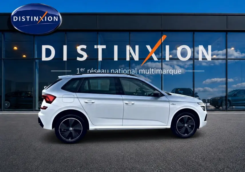 Profil droit d’un Skoda Kamiq blanc nacré version Monte Carlo 2026, avec jantes noires et toit panoramique visible.