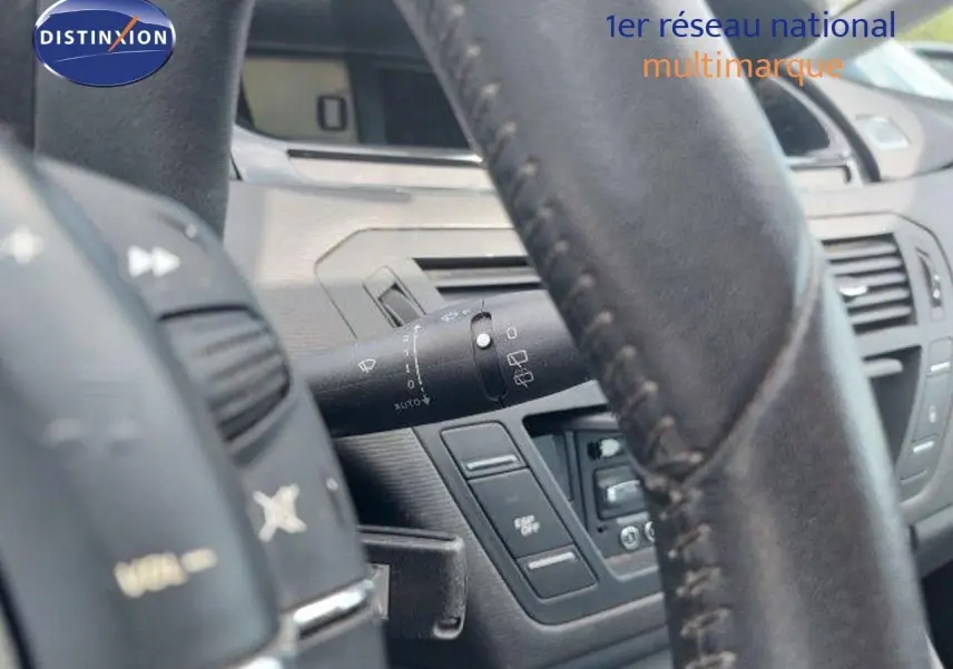 Gros plan sur le volant en cuir noir et la commande d'essuie-glace du tableau de bord intérieur d'une Citroën C4 Picasso 2013.