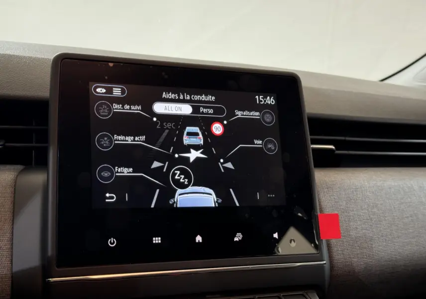 Écran tactile central affichant les aides à la conduite dans l’habitacle d’une Renault Clio gris clair 2025.