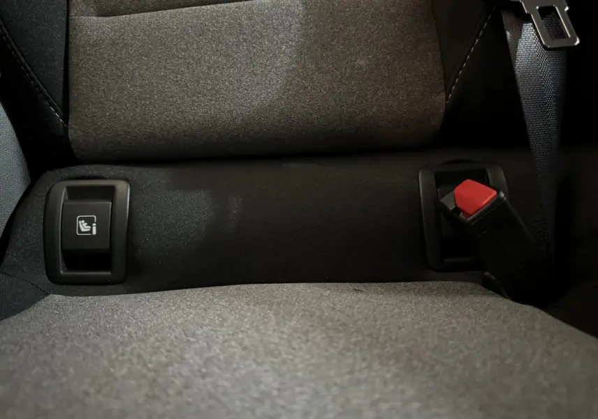 Gros plan sur la banquette arrière grise de la Renault Clio 2025 avec ceinture et bouton Isofix visible.