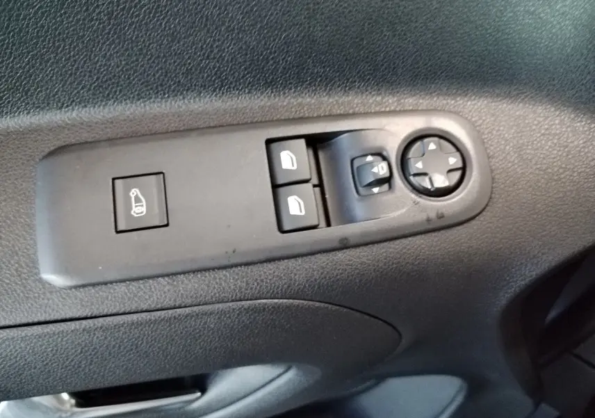 Gros plan sur les commandes de réglage des rétroviseurs et des vitres côté conducteur du Citroën Berlingo gris acier 2025.