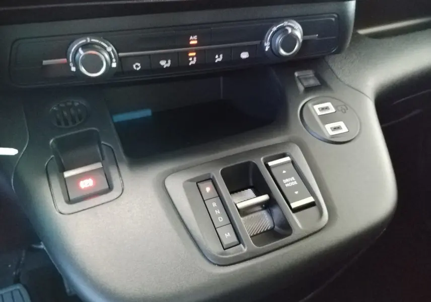 Gros plan sur la console centrale du Citroën Berlingo gris acier 2025, montrant la commande de boîte auto et les réglages climatiques.