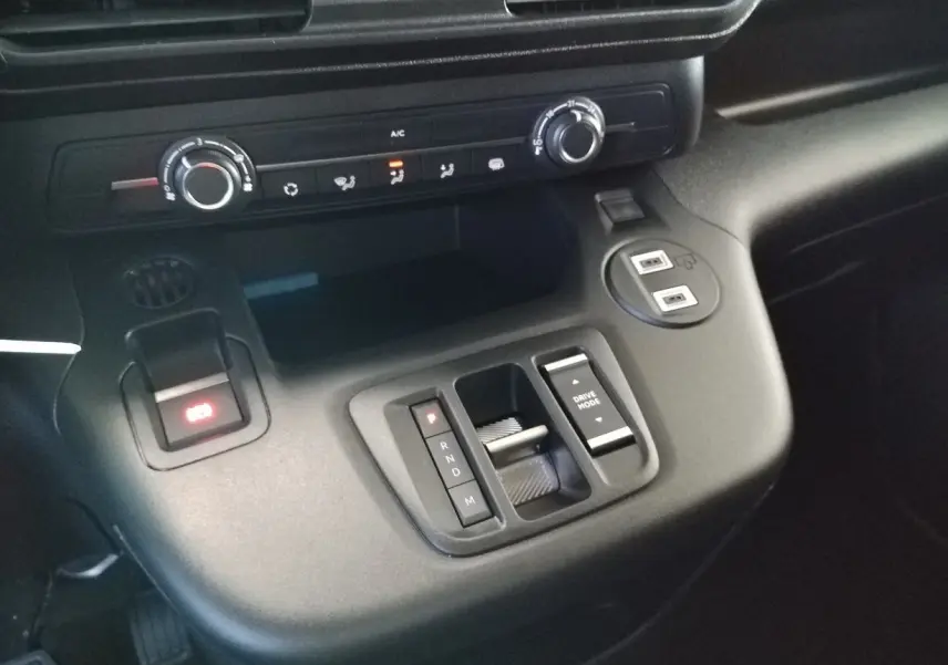 Vue rapprochée de la console centrale du Citroën Berlingo gris acier 2025, avec commandes de boîte auto et climatisation.