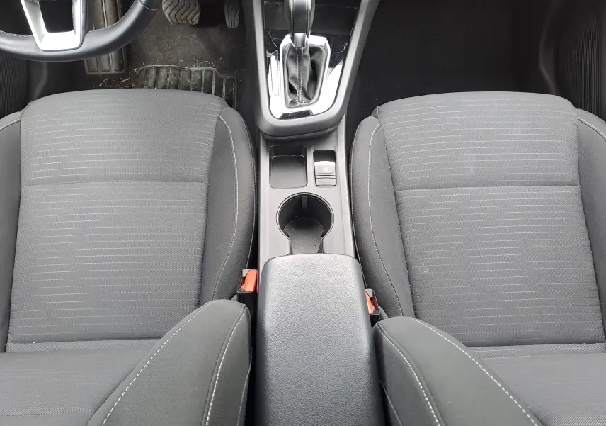 Vue plongeante sur les sièges avant en tissu noir et la console centrale avec levier de vitesse de la Renault Arkana 2023.