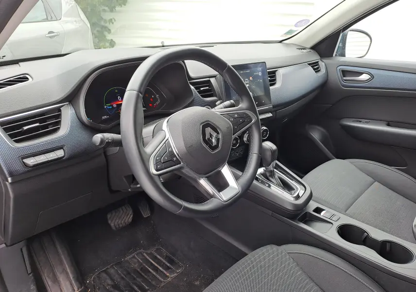 Intérieur noir du Renault Arkana 2023, vue côté conducteur sur le volant, tableau de bord digital et console centrale.