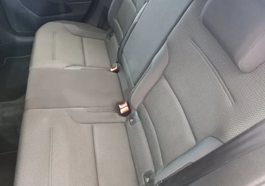 Banquette arrière gris foncé vue de côté gauche dans une Volkswagen Golf 2019, tissu texturé avec ceintures visibles.