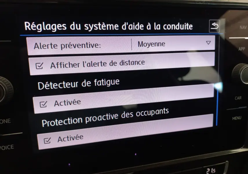 Écran tactile central affichant les réglages d'aide à la conduite dans une Volkswagen Golf gris foncé de 2019