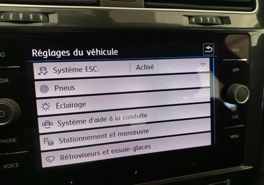 Écran tactile central affichant les réglages du véhicule dans une Volkswagen Golf gris foncé, vue intérieure rapprochée.