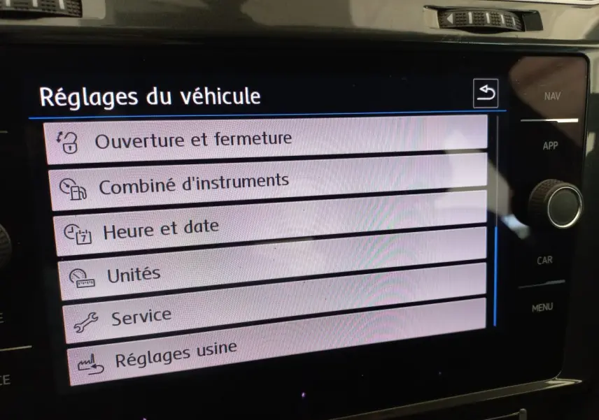 Écran tactile central affichant le menu Réglages du véhicule dans une Volkswagen Golf gris foncé, vue rapprochée intérieure.