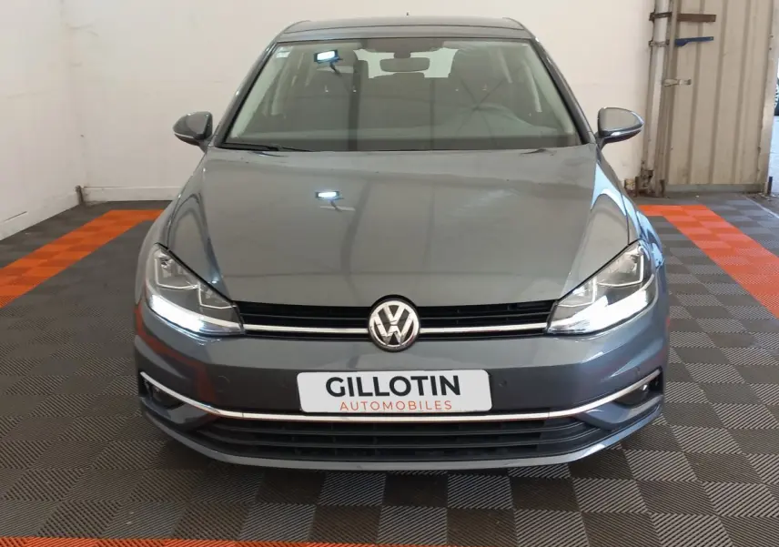 Vue frontale d'une Volkswagen Golf gris foncé 2019 avec phares LED et plaque GILLOTIN Automobiles.