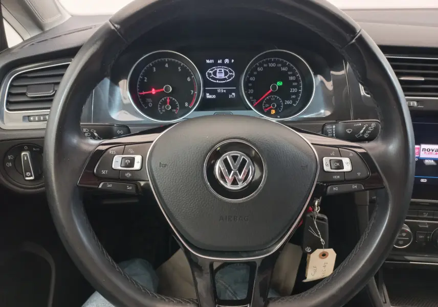 Vue rapprochée du volant cuir noir et du tableau de bord numérique d'une Volkswagen Golf gris foncé de 2019.