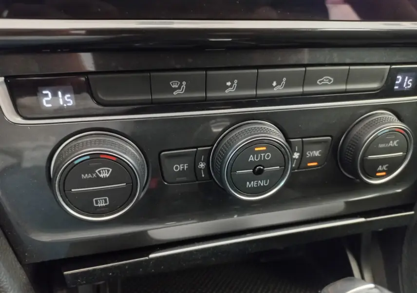 Vue rapprochée des commandes de climatisation digitale à double zone sur la Volkswagen Golf gris foncé 2019.