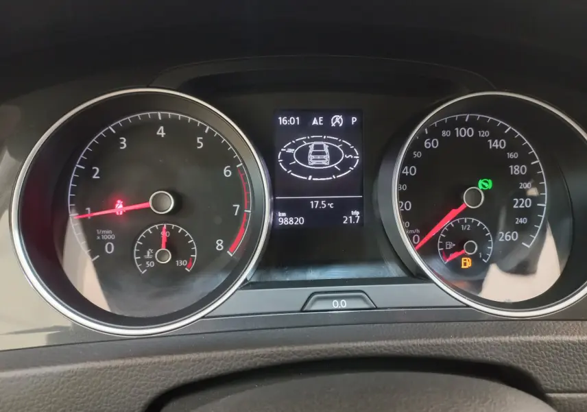 Tableau de bord de Volkswagen Golf 2019 avec compte-tours, vitesse, écran central affichant température et alertes de sécurité.