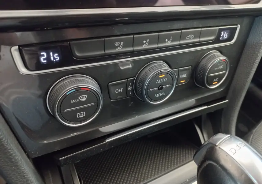 Gros plan sur la console centrale de la Volkswagen Golf 1.0 TSI 115 DSG7, avec commandes de climatisation digitale à 21,5°C.