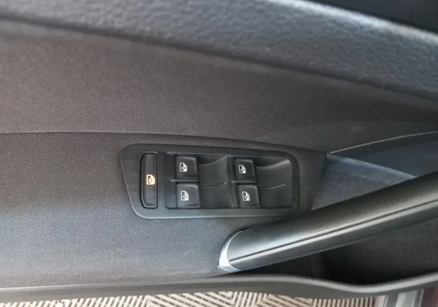 Commandes des vitres électriques sur la porte côté gauche d'une Volkswagen Golf gris foncé, finition Confort Business.