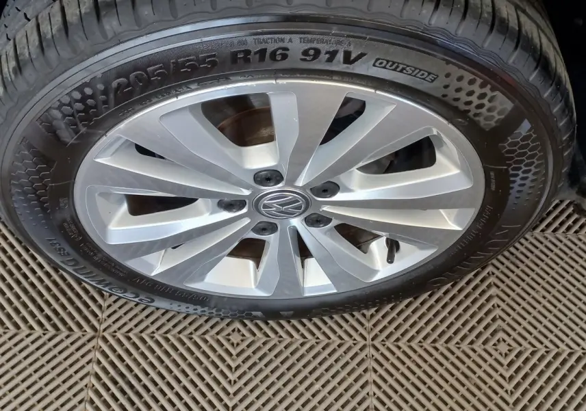 Gros plan sur la jante argentée et le pneu 205/55 R16 d'une Volkswagen Golf gris foncé de 2019.