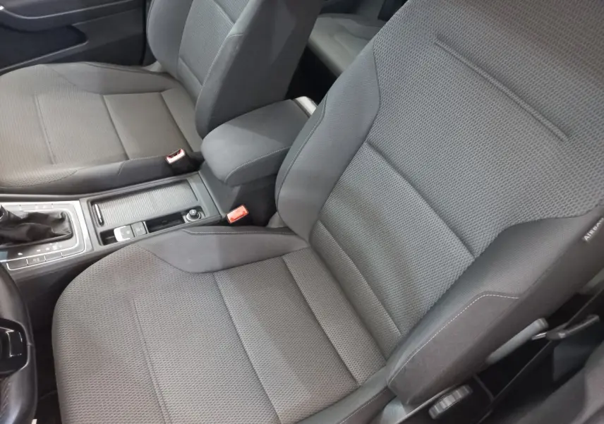 Gros plan sur les sièges avant gris tissu et la console centrale d'une Volkswagen Golf 2019 côté conducteur.