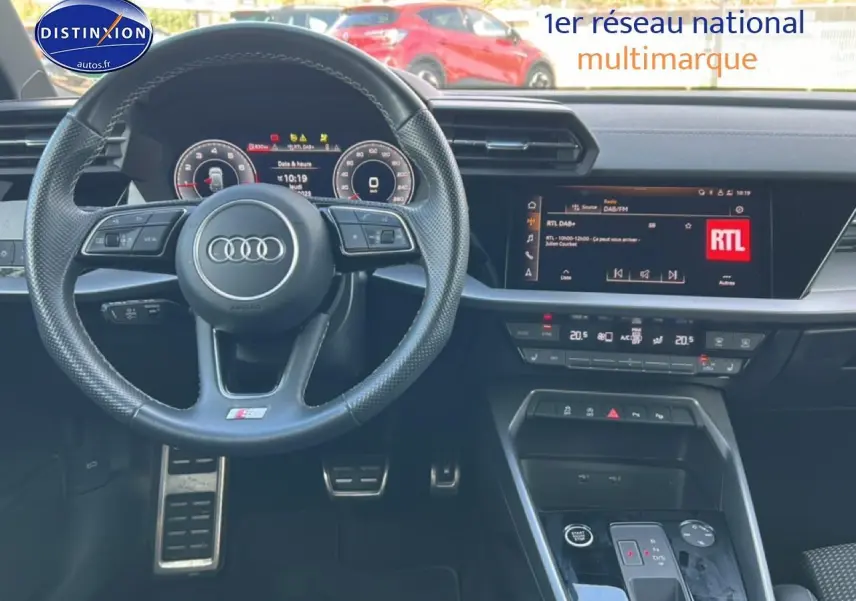 Intérieur Audi A3 Sportback 2024 noir, vue du tableau de bord avec volant multifonction et écran tactile central.