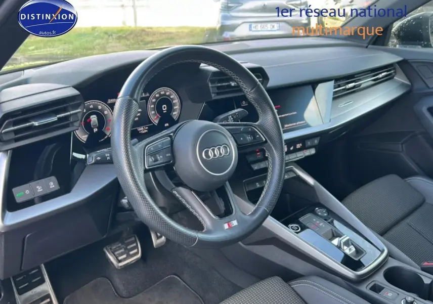 Intérieur noir de l'Audi A3 Sportback 2024 vu côté conducteur, volant cuir multifonction et tableau de bord digital.