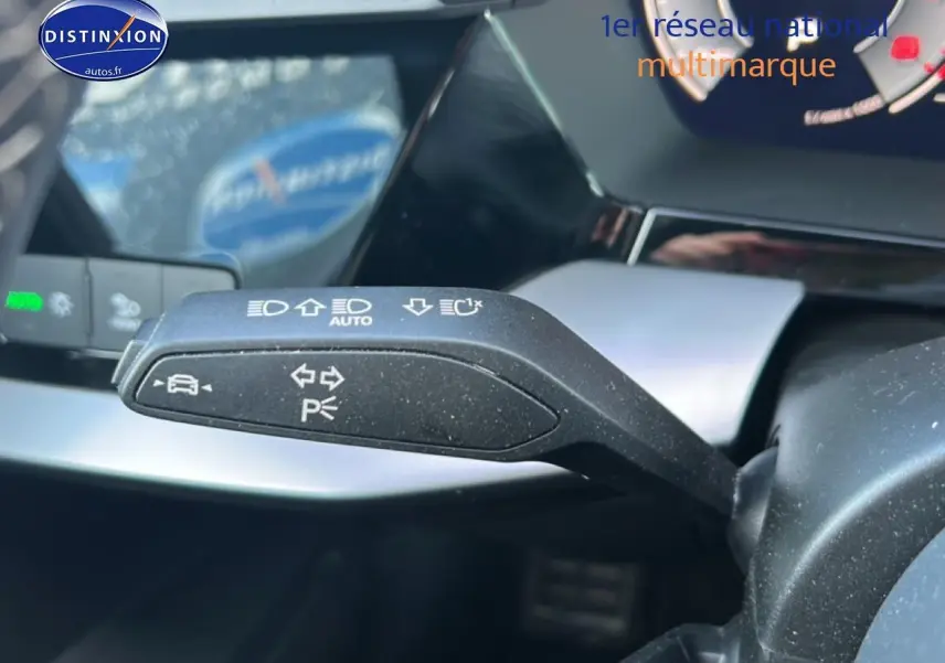 Gros plan sur la manette de clignotants à gauche du volant dans l'habitacle d'une Audi A3 Sportback noire 2024