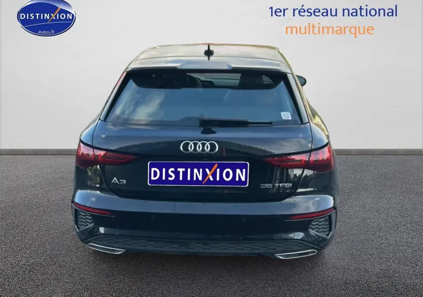 Vue arrière d'une Audi A3 Sportback noire 2024 avec feux LED et double sortie d'échappement chromée.