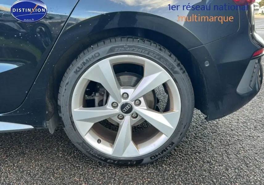 Gros plan sur la roue arrière droite noire d'une Audi A3 Sportback 2024 avec jante argentée à 5 branches.