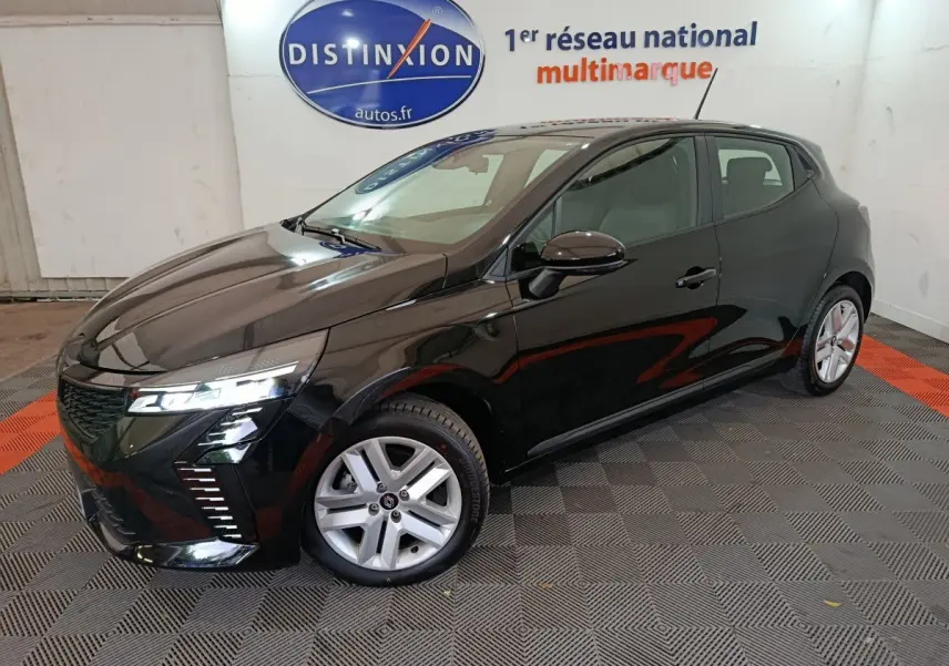 Renault Clio Evolution Blue dCi 100 2025 noire vue 3/4 avant droit avec phares LED allumés en intérieur showroom.