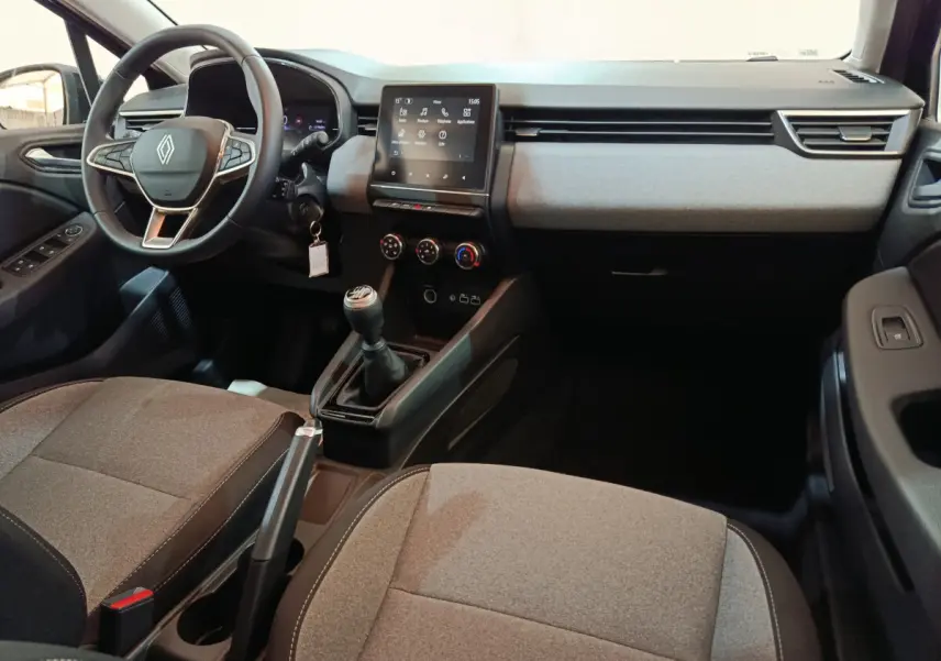 Intérieur avant de la Renault Clio Evolution Blue dCi 100 2025, vue côté conducteur, sièges gris et tableau de bord moderne.